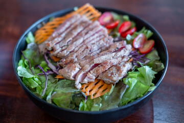 Salad with sliced medium rare meat served on plate