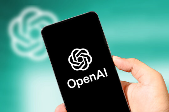 Person showing OpenAi mobile app with green blur background, illustrative editorial. Chatgpt mobile application concept backdrop