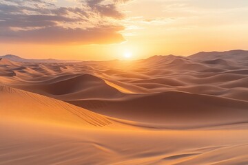 Vast desert landscape with rolling sand dunes under a dramatic sunset, creating a golden hue across the endless sandy expanse.