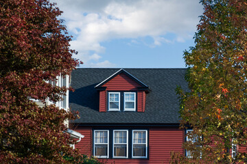 Autumn large trees frame a charming family house in Watertown, Massachusetts, USA
