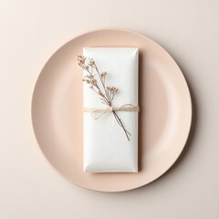 A simple wrapped gift with delicate floral accent, placed on a soft, pastel plate, evokes elegance and charm for special occasions