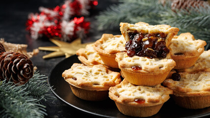 British Christmas mince pies or fruit pie with decoration, gifts, green tree branch
