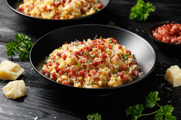 Carbonara fried rice with pancetta, pecorino romano cheese, eggs in a black bowl
