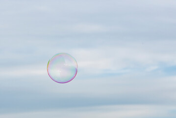Einzelne Seifenblase am Himmel in Regenbogenfarben