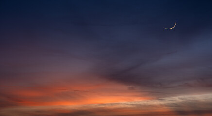Dusk sky, Crescent moon on twilight dark blue hour sky background, Religion of Islamic well space for text Ramadan Kareem, Eid Al Fitr, Eid Al Adha, Eid Mubarak  