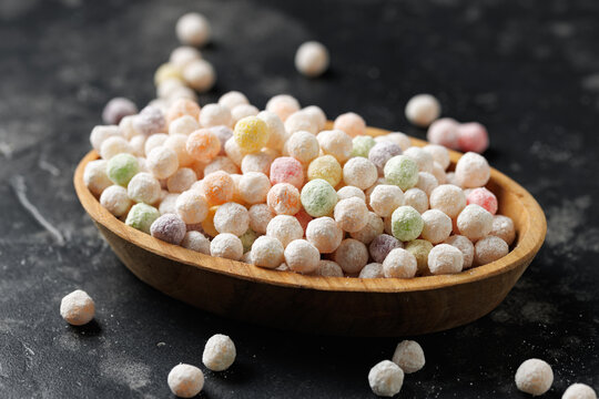 Colorful uncooked tapioca pearls in wooden bowl