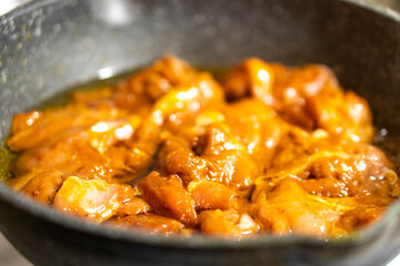 Chicken pieces are fried in a frying pan. Meat cooking. Food concept