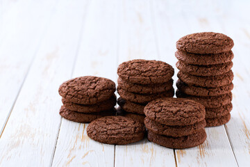Small pile of delicious сhocolate cookies with a light kitchen table, selective focus.