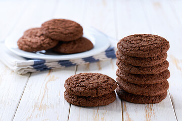 Stack of American chocolate cookies on a white table, selective focus.