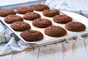 Baking pan with american chocolate cookies , on a light kitchen table, selective focus.