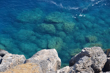 a rocky cliff with clear water and low waves top view wallpaper