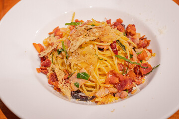 High angle, Stir-fried spaghetti with bacon, dried chili, garlic and thai herbs on white plate