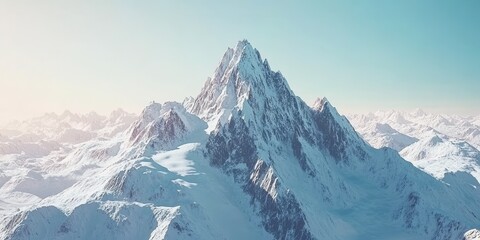 Obraz premium Stunning snow-covered mountain peak under a clear blue sky during golden hour.