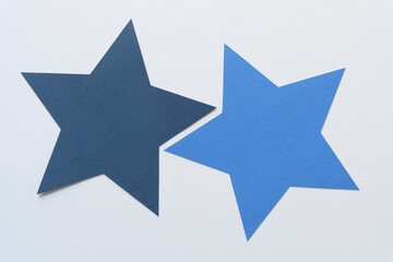 Obraz premium two machine-cut blue paper stars on blank paper