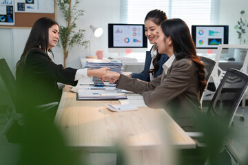 Businesswomen shaking hands after reaching an agreement during a meeting in a modern office, demonstrating collaboration and partnership