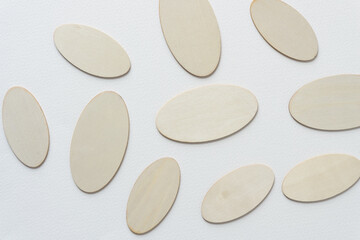 laser-cut wooden oval or ovoid shapes arranged on blank paper