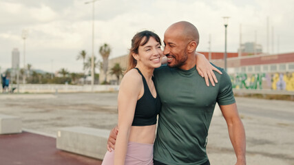 Close up of young cheerful couple in love strolling along the waterfront in the morning. A pleasant conversation with joy, a couple walking and cuddling. Couple goals