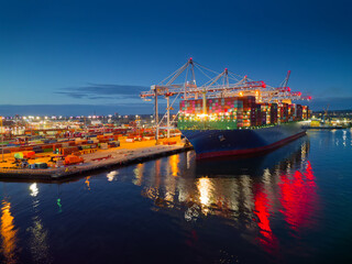 Illuminated Southampton UK container terminal with large container ship at dusk. Beautiful light...