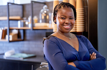 Attractive African American female boss smiling at camera standing in modern office breakroom...