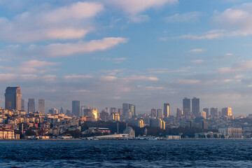 Fototapeta premium A stunning cityscape of Istanbul, bathed in the warm glow of the sunrise. The city skyline stretches across the horizon, showcasing a mix of modern skyscrapers and traditional Ottoman architecture.