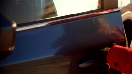 Person wearing red coat opening car door