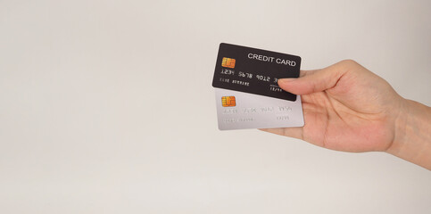 Hand is hold black and silver credit card on white background..
