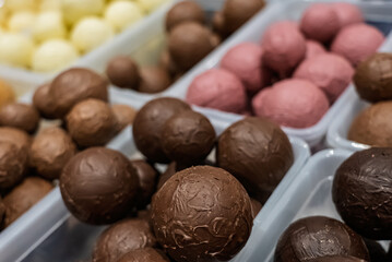 Close up of assorted chocolate truffles in various colors and textures. Colorful chocolate balls. Sweets handmade chocolate balls.
