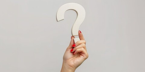 A woman's hand is seen up close clutching a large question symbol in a 3D model on a white studio background with a large copy space, Generative AI.