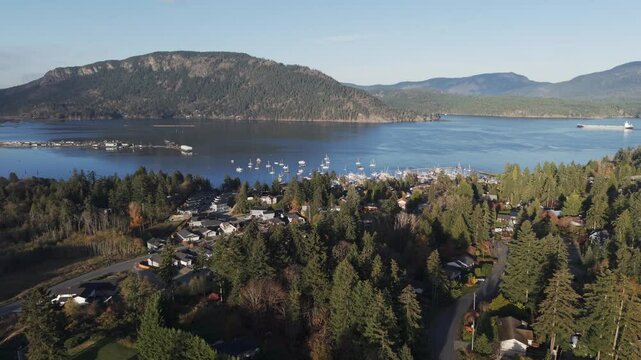 Aerial video of houses overlooking Cowichan Bay with mountains in the distance, Vancouver Island, British Columbia, Canada.