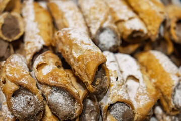 Cannoli, Sicilian pastry consisting of a tube shaped shell of fried pastry dough, filled with a sweet, creamy filling containing ricotta cheese. Italian cannolo and Sicilian cannolu.