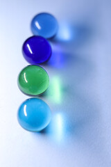 colorful glass marbles dropping colorful reflection on white background