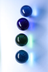 colorful glass marbles dropping colorful reflection on white background