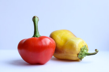 Red and yellow peppers on a white background. Selective focus.