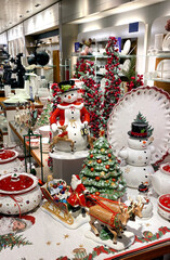 A lot of New Year's porcelain toys in a vintage style, Santa Klaus, snowman, plates and a deer in a supermarket on the Christmas Sale. Bijenkorf.