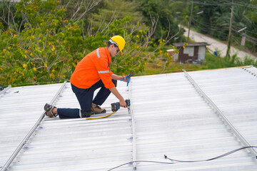 Men technicians mounting photovoltaic solar moduls on roof of house.