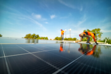 Men technicians mounting photovoltaic solar modules. Builder mounting photovoltaic solar modules on roof of house.
