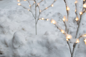 Twinkling Frost: An Illuminated Artificial Tree in a Snow-Covered Yard.  Enchanting Frost: A Lit...