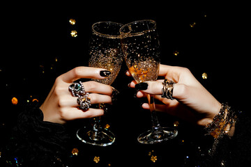 Feminine Hands with Jewelry Holding Champagne Glasses for Cheers on New Year's Eve