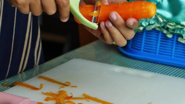 4k video clean the carrot bones and cut the carrots on a board.