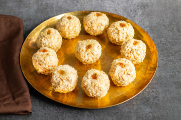 Moa is a traditional Bengali sweet made of puffed rice, jaggery, and coconut, often shaped into small, round balls.