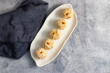 Moa is a traditional Bengali sweet made of puffed rice, jaggery, and coconut, often shaped into small, round balls.