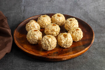 Moa is a traditional Bengali sweet made of puffed rice, jaggery, and coconut, often shaped into small, round balls.
