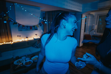A lively group of friends celebrates a birthday in a cozy living room. The room is beautifully...