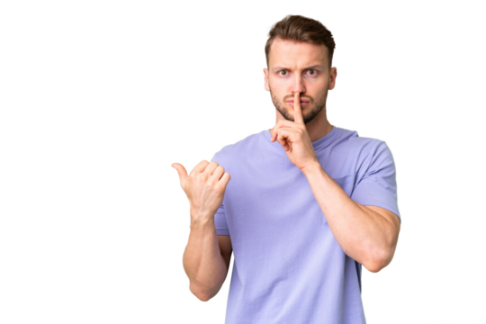 Young handsome caucasian man over isolated chroma key background pointing to the side and doing silence gesture