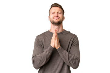 Young handsome caucasian man over isolated chroma key background keeps palm together. Person asks for something