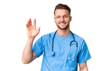 Young nurse man over isolated chroma key background saluting with hand with happy expression