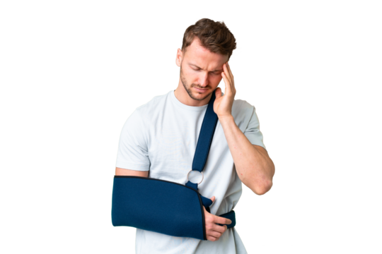 Young caucasian man with broken arm and wearing a sling over isolated chroma key background with headache