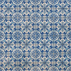 Fragment of building wall with colorful ceramic wall tiles. Azulejo close up. Abstract decorative background, textured ornate pattern for design or backdrop. Traditional ornate Portuguese architecture