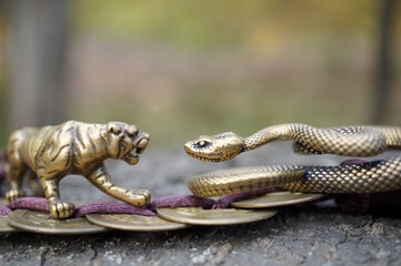 A snake and tiger figurine with Chinese coins.