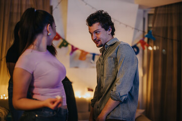 A lively group of friends gather in a cozy living room decorated with a birthday banner. The warm atmosphere exudes joy and camaraderie as they celebrate together.